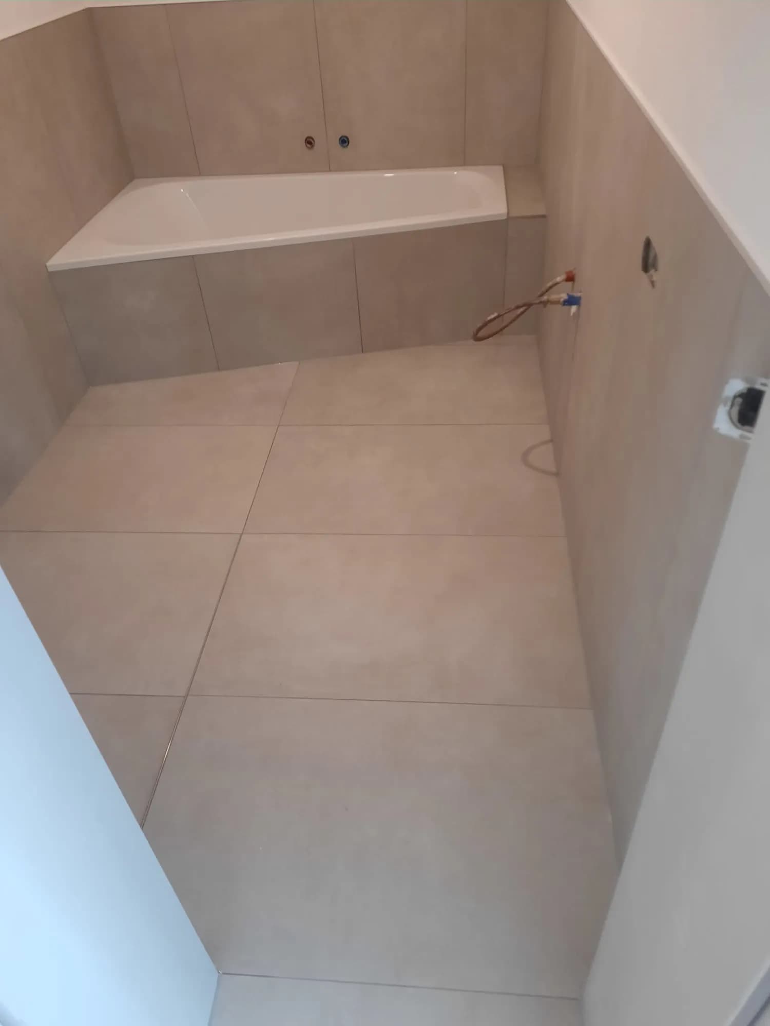Professionell verlegte Eckbadewanne mit modernen Großformatfliesen in Schieferoptik 4