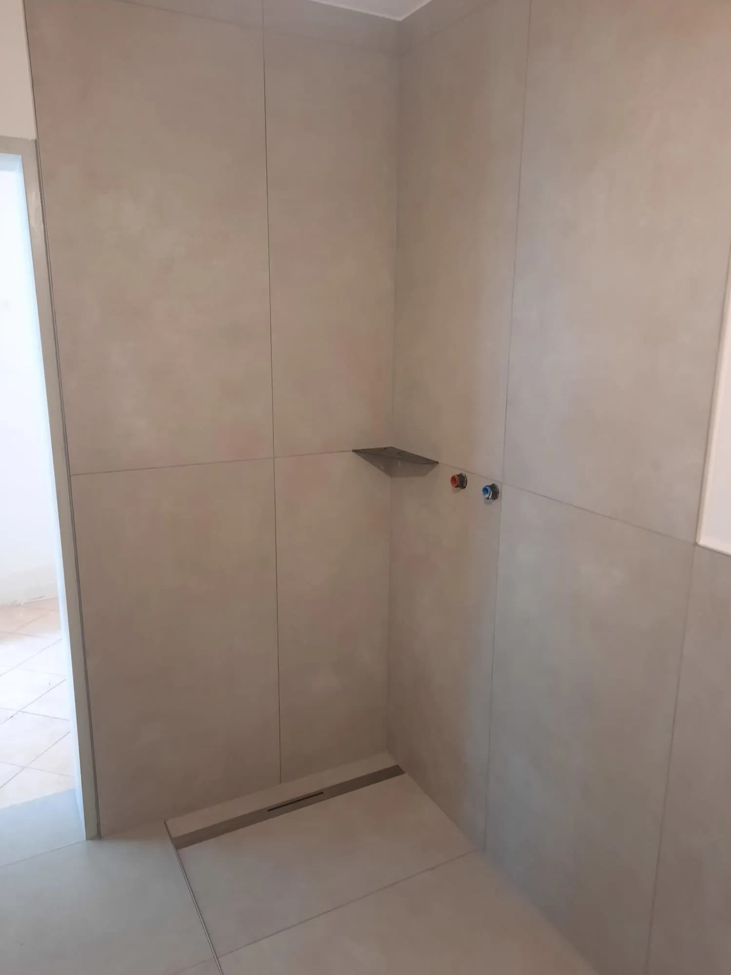 Professionell verlegte Eckbadewanne mit modernen Großformatfliesen in Schieferoptik 3